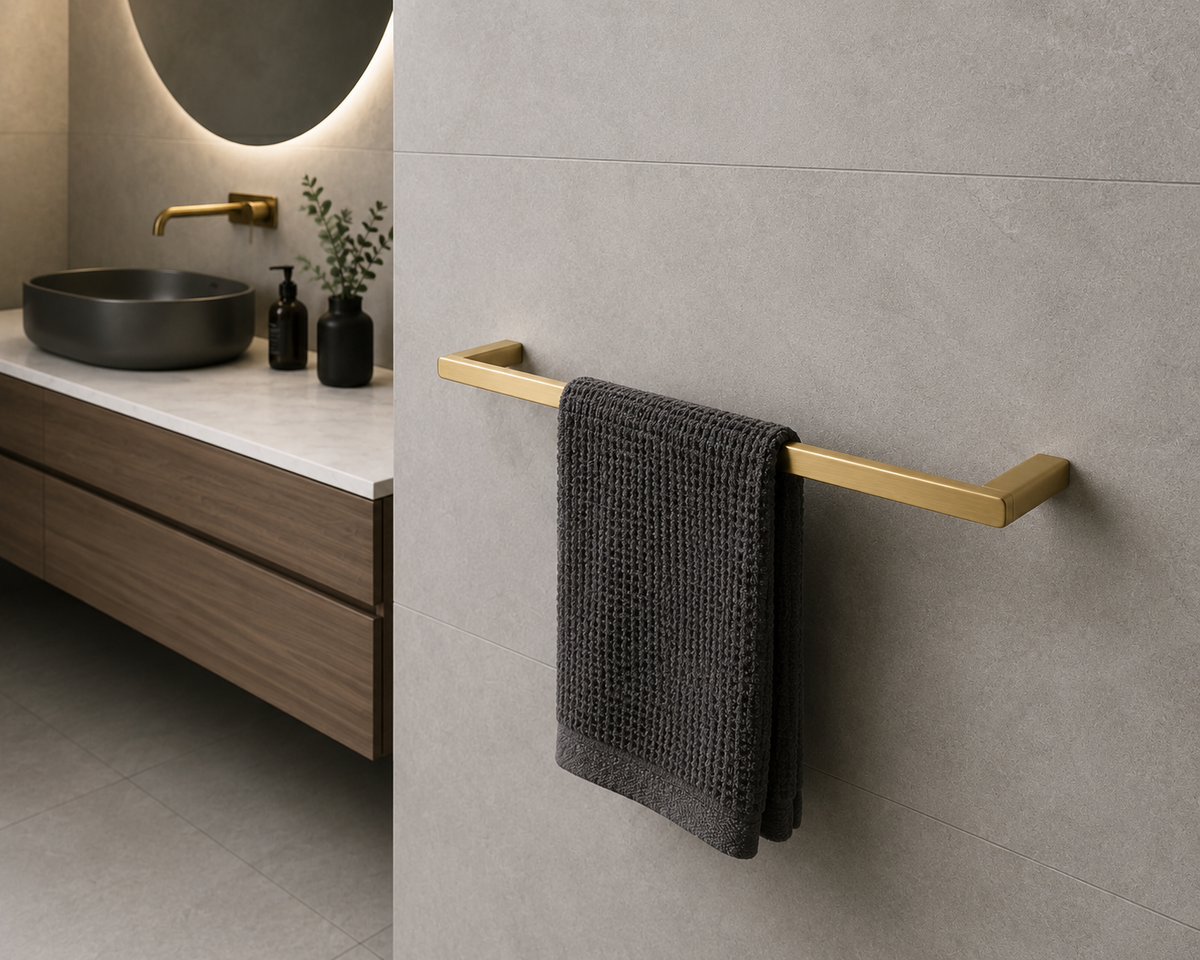 A matte black wall-mounted towel bar with a dark gray textured towel hanging on it, shown in a modern bathroom setting with a gray vessel sink and wood vanity in the background.